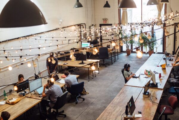 An image of a cool coworking space with fairy lights and people on computers.