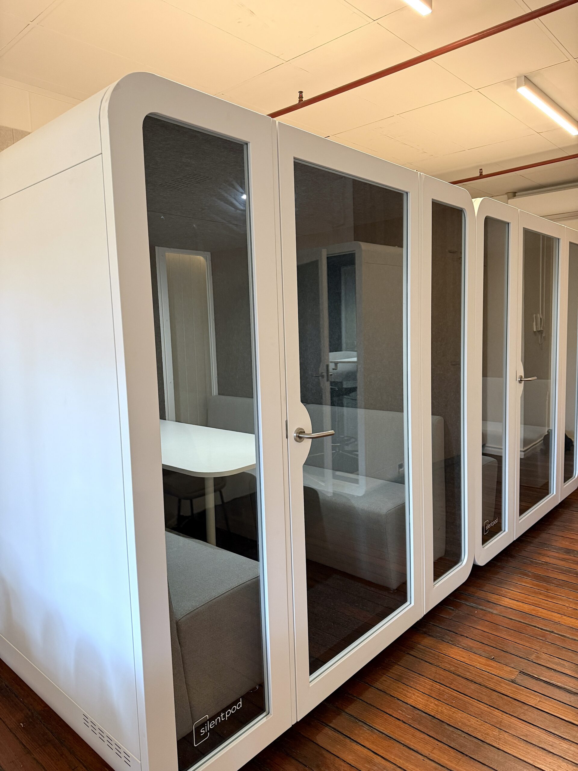 Boardroom privacy pods on site, with couches and a table, suitable for up to 8 people.