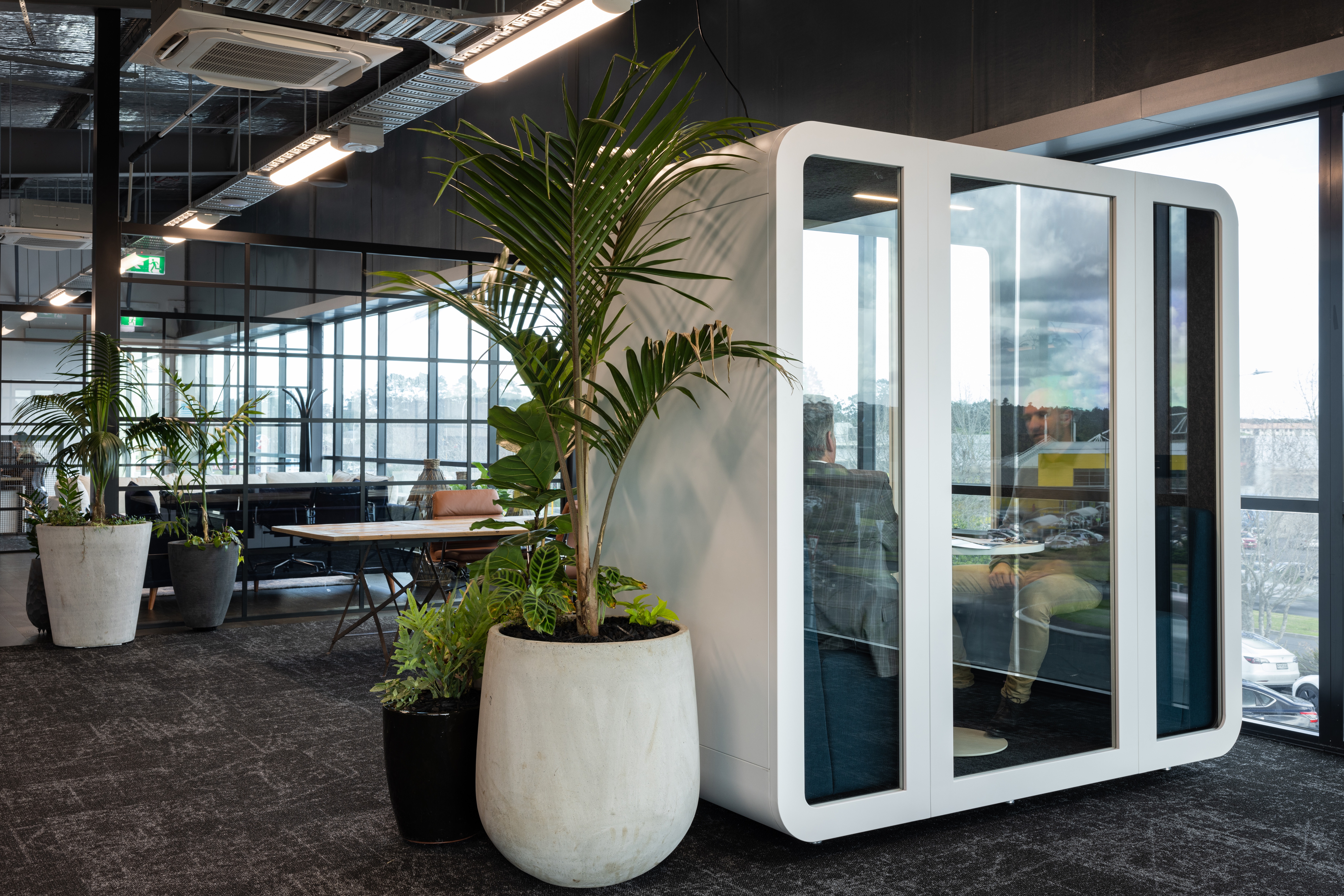 Two people having a private discussion inside of a silent pod Collab Pod (Privacy office pod)
